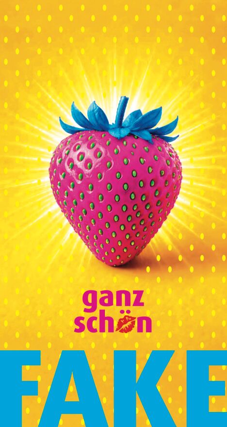 Eine Erdbeere mit blauen Blütenblättern, blauem Stiel und giftgrünen Kernen ist von einem hellen Lichterkranz umgeben. Darunter steht "ganz schön Fake" in Großbuchstaben..
