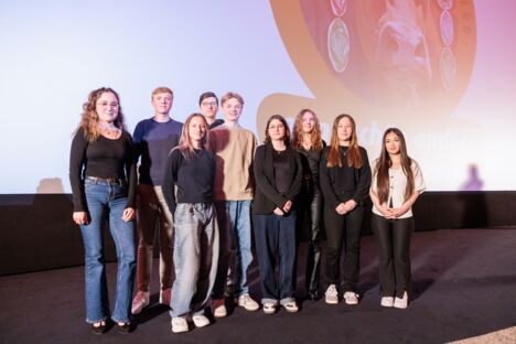 Neun Schüler*innen stehen auf der Bühne des Astor Kinos in Hannover und blicken in die Kamera.