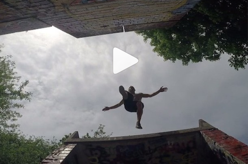 Janis Geiger, Parkour-Sportler Janis Geiger springt über zwei Gebäude - auf dem Foto sieht man ihn von unten.